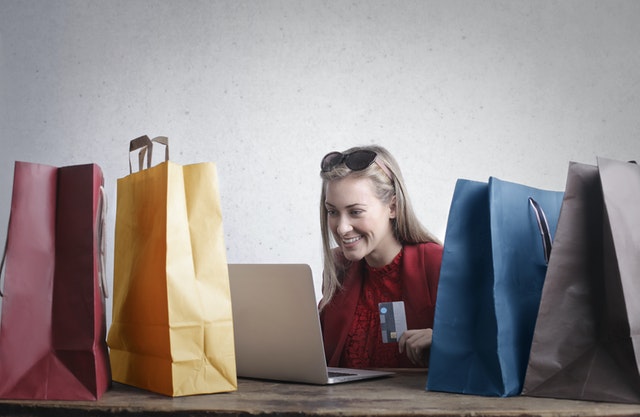vantagens e desvantagens do cartão de crédito - compras impulsivas - moça animada com diversas sacolas ao redor compra mais
