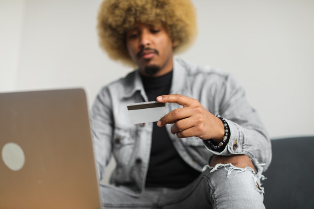 erros financeiros - homem usa cartão de crédito para compra online