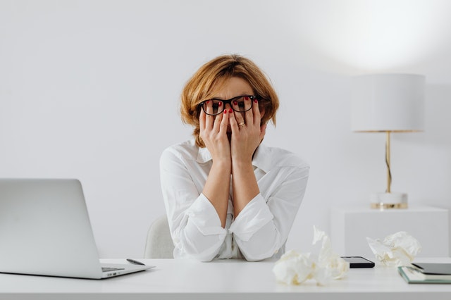erros financeiros comuns - mulher se desespera em frente ao computador