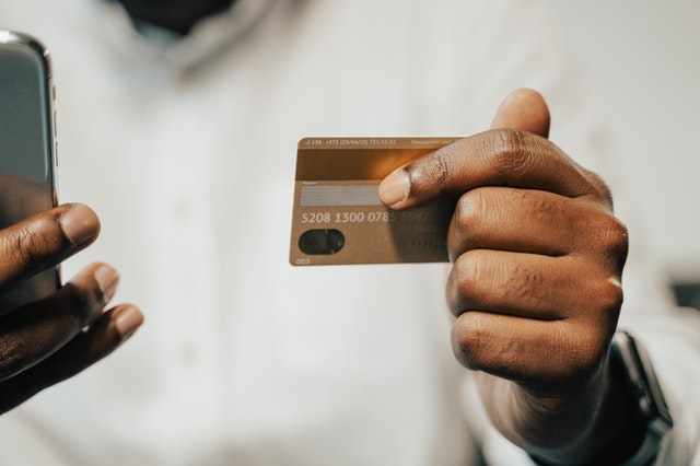 dívida no cartão de crédito - pessoa consulta cartão para pagamento no celular